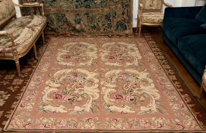 Tapis, tapisserie à l'aiguille, cartouches fleuris sur fond rose, XXe siècle.