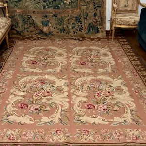 Tapis, tapisserie à l'aiguille, cartouches fleuris sur fond rose, XXe siècle.